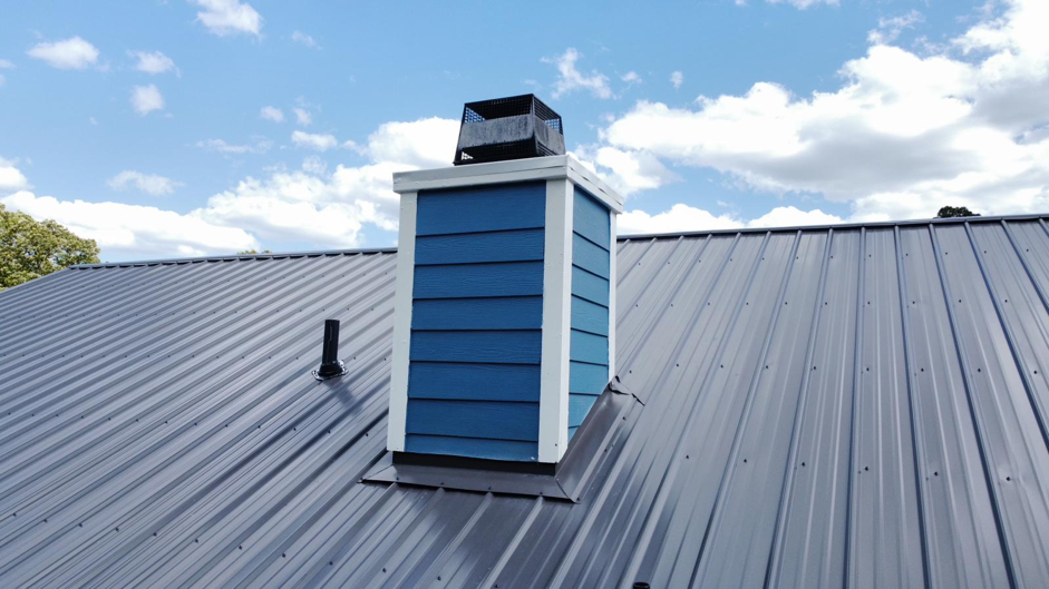 Closeup of a Gray Metal Roof and Blue-painted Chimney