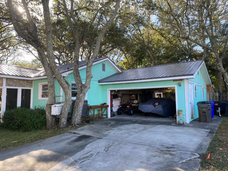 View of a Home’s Garage, Featuring Green Walls and Dark Metal Roofing